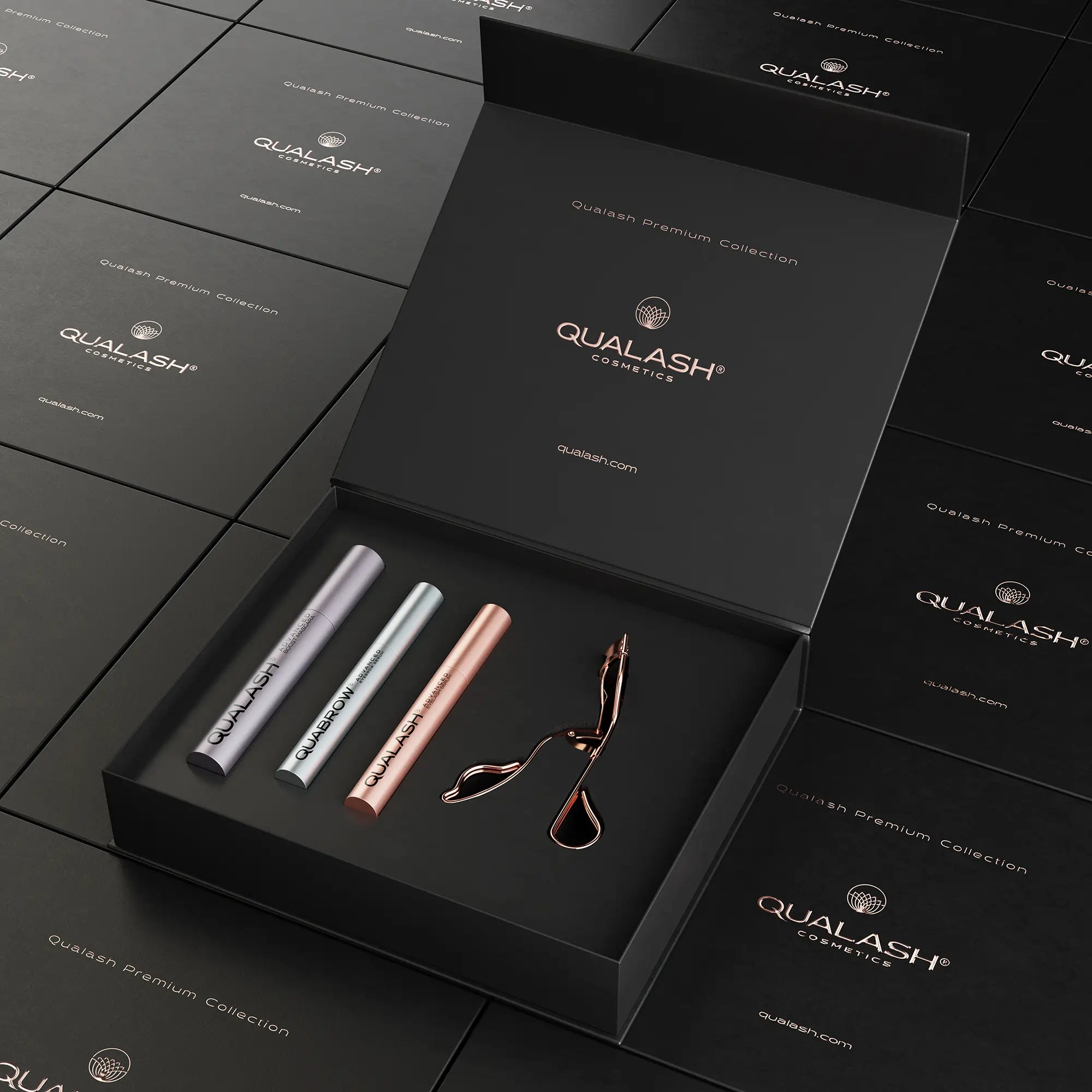 Boîte Qualash Premium Collection ouverte avec recourbe-cils et trois sérums à l’intérieur