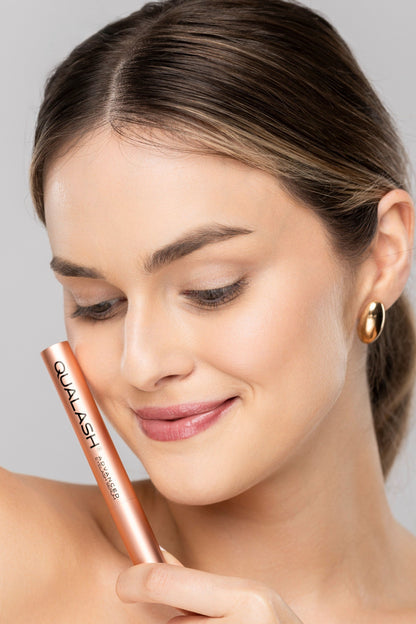 Woman with natural makeup and enhanced lashes using QUALASH lash serum
